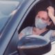 Bored woman with protective face mask waiting in the car
