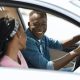 Young black lady helping her husband driver with road map